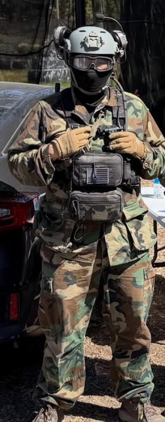 Julian of Mike Force Irregulars in woodland camo with helmet and goggles at an airsoft field