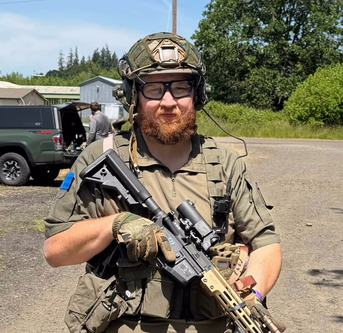 Scott Watkins of Mike Force Irregulars in airsoft kit with helmet and rifle at a Pacific Northwest field